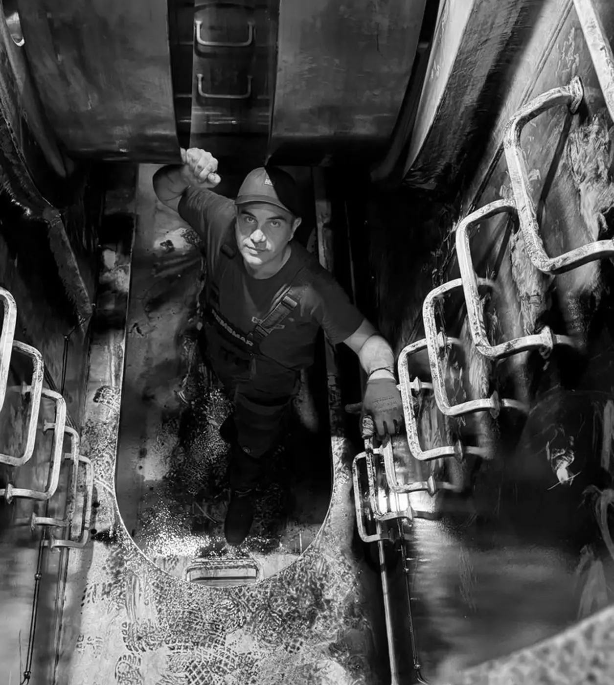 Technician working inside a confined marine engine compartment